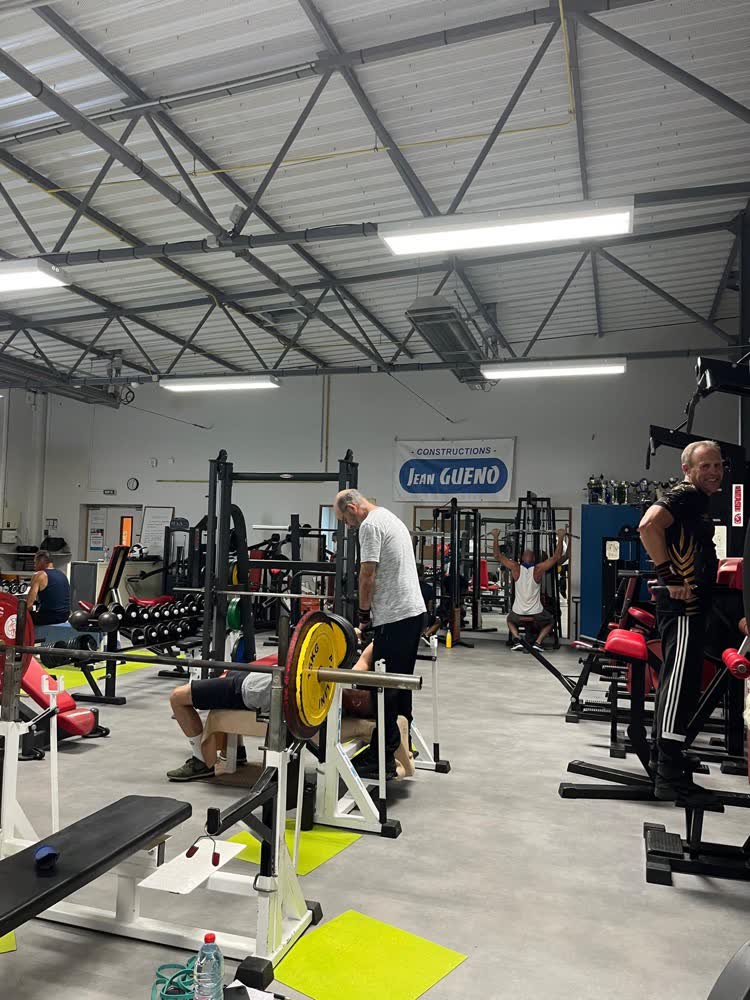 Adhérents à l'entraînement entre les racks de la salle de musculation SGHM à Guérande